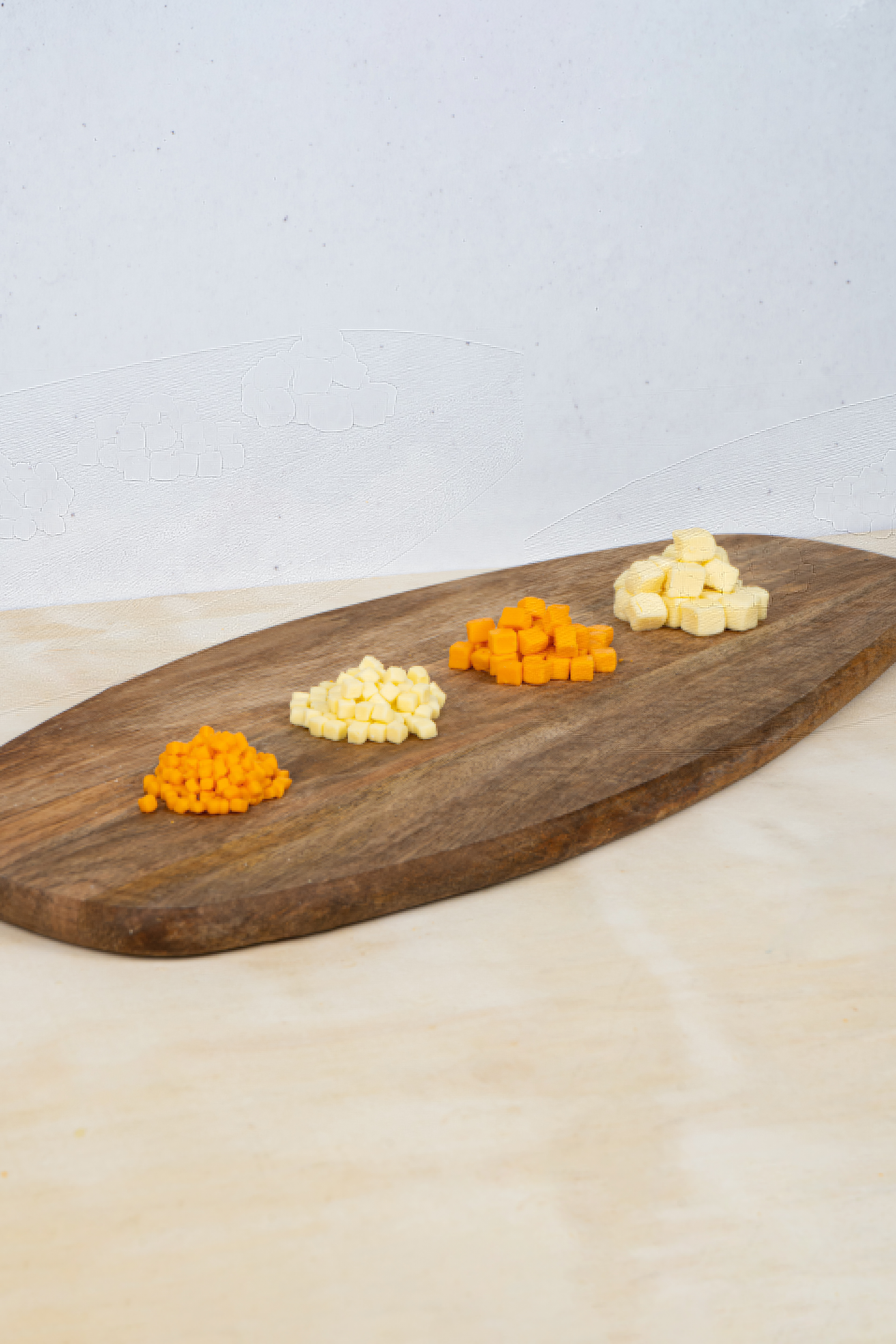 Four varieties of FT Cheese diced cheese on a wooden board
